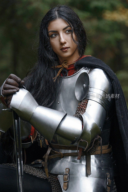 一个美丽的战士女孩带着剑，穿着链甲和盔甲在一个神秘的森林。