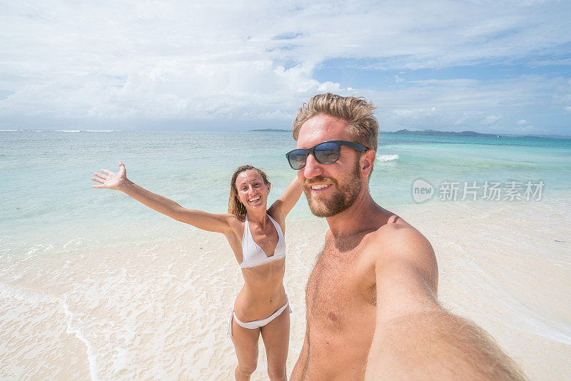 年轻夫妇在热带海滩自拍