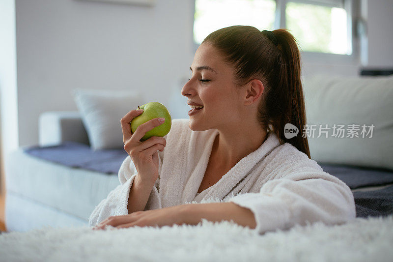 女人在家边听音乐边吃苹果