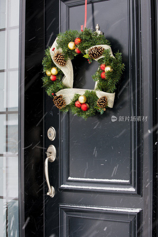 圣诞花环挂在黑色的门上。