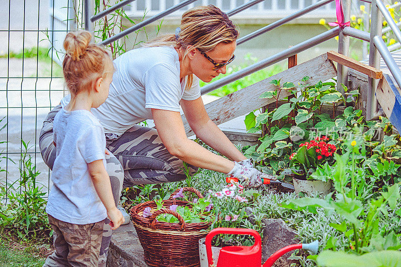 母亲和女儿一起在花园里干活