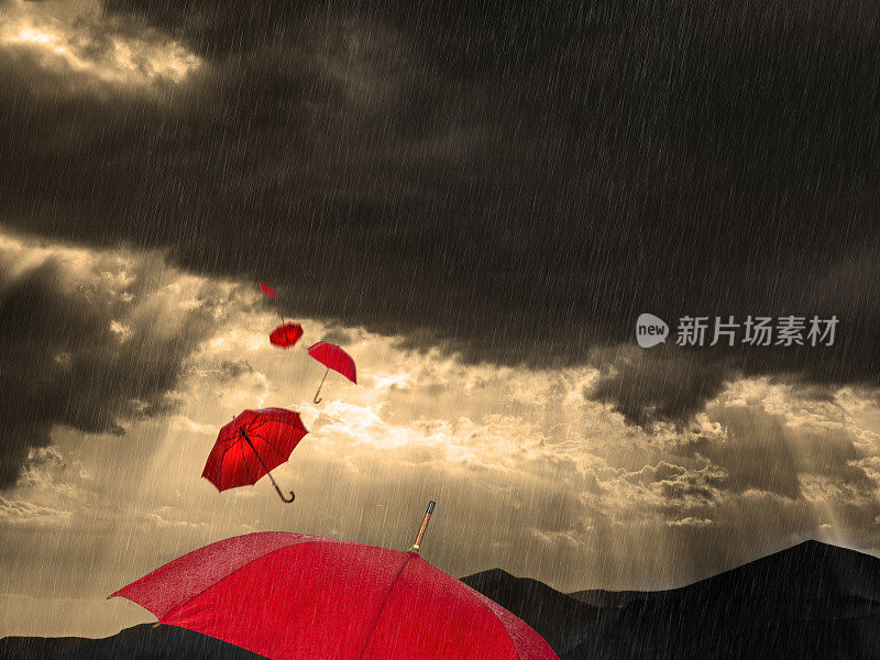 在希腊，红色的雨伞在暴风雨的天气和风景中飞舞