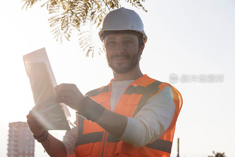 建筑工程师在建筑场地控制数据表和戴安全帽