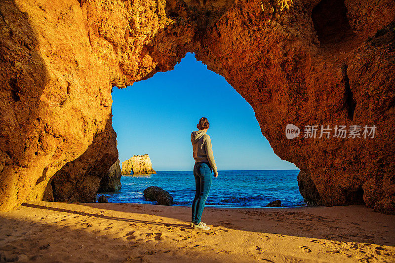 年轻的黑发女性享受她的自由在阿尔沃葡萄牙海滩在夏末的太阳