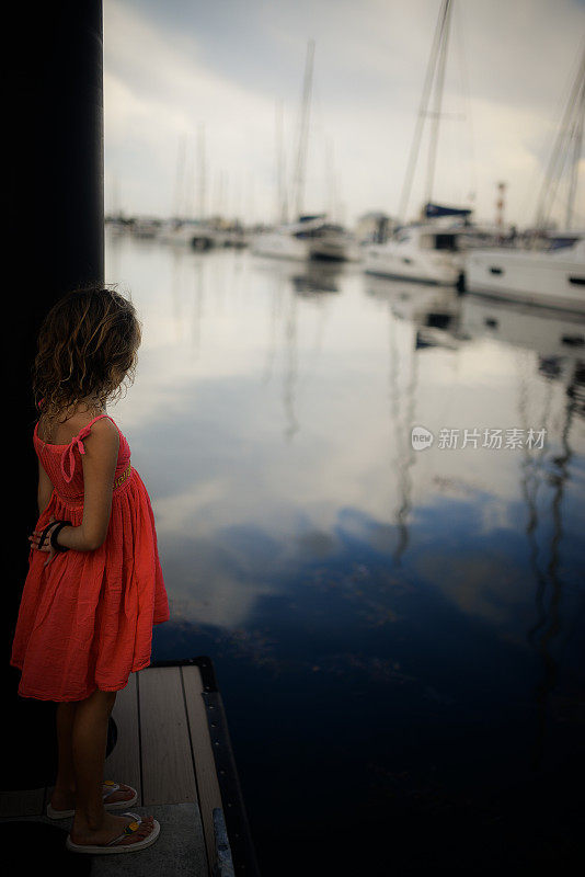 码头上的女孩穿着裙子，孩子和海岸线