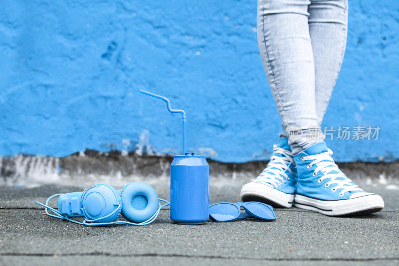 蓝色耳机，蓝色罐子和太阳镜靠在地上