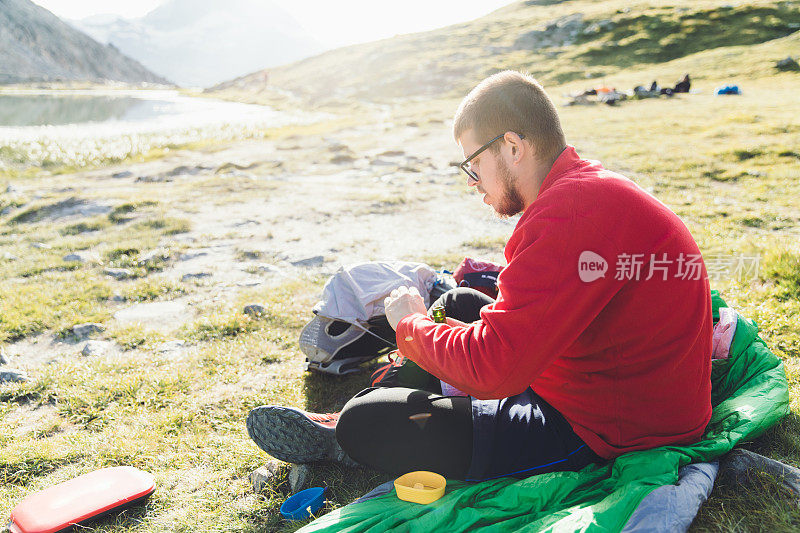 在瑞士阿尔卑斯山进行夏季野餐的背包客