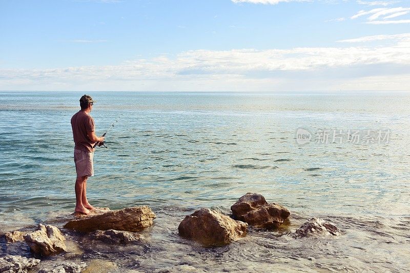 在海岸岩石上钓鱼的人