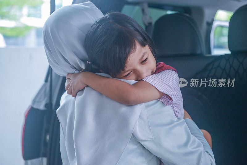亚洲穆斯林年轻母亲拥抱准备离家上学的女儿