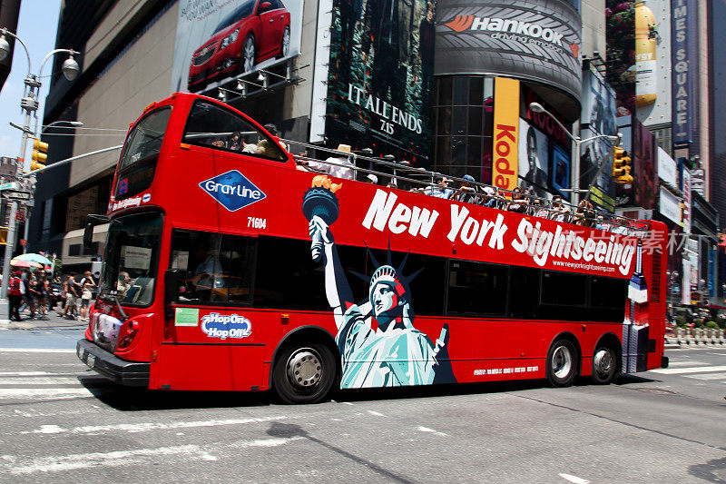 时代广场上模糊的红色纽约观光巴士与游客在夏天的一天