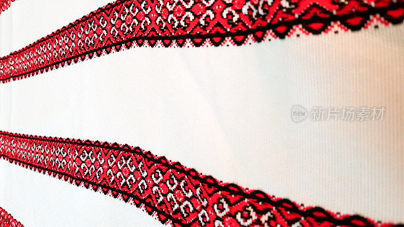 乌克兰民间手工刺绣。用红黑线绣在白色织物上的装饰品。用黑色和红色的线绣的装饰品。白色织物上的乌克兰民族民间刺绣