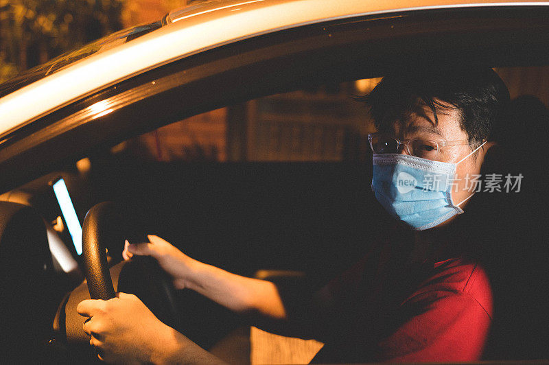 亚洲男性网约车司机戴着口罩使用智能手机