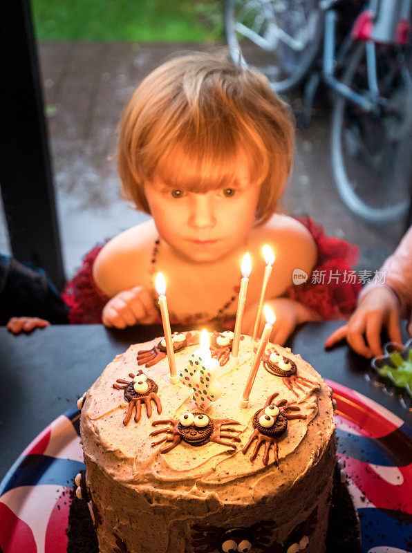 小女孩在生日派对上吹蜡烛