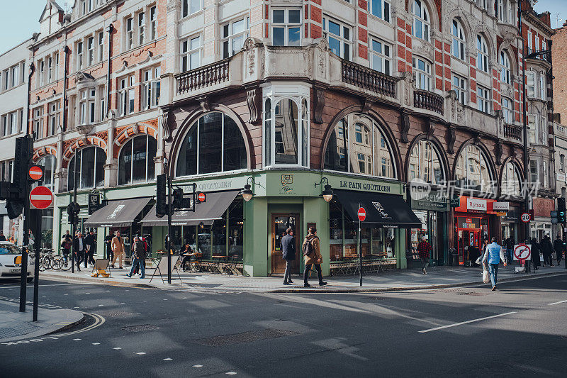人们走过英国伦敦菲茨罗维亚的商店和餐馆。