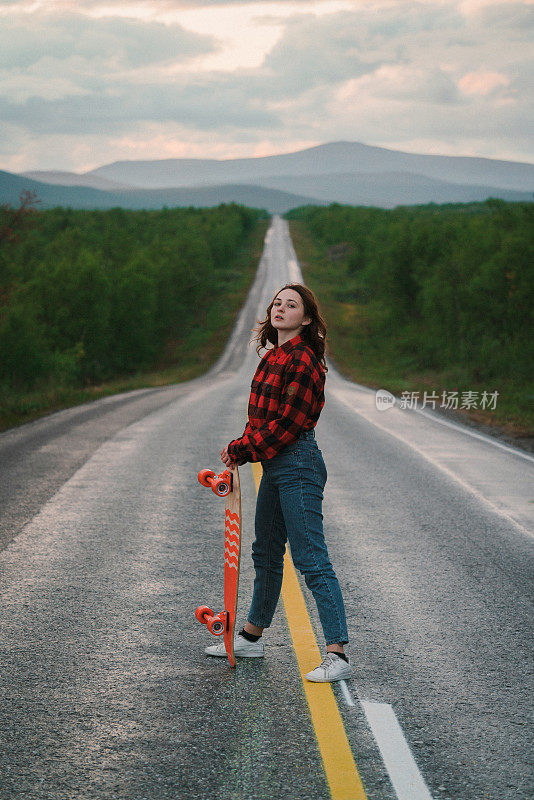 芬兰的一名女子在路上玩长滑板