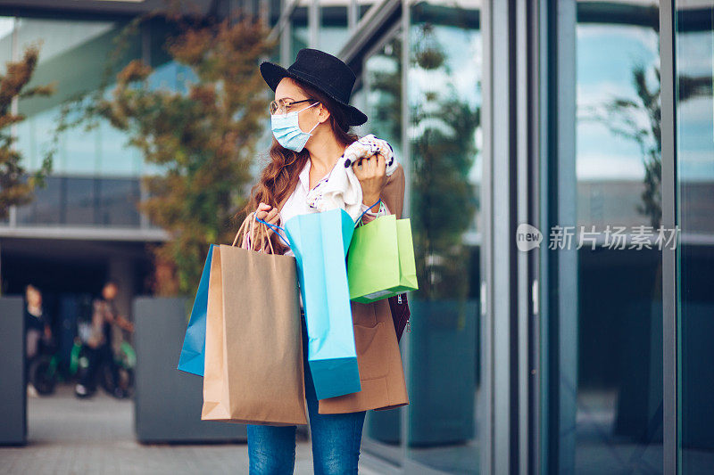 美丽的女人戴着保护面罩在shooping