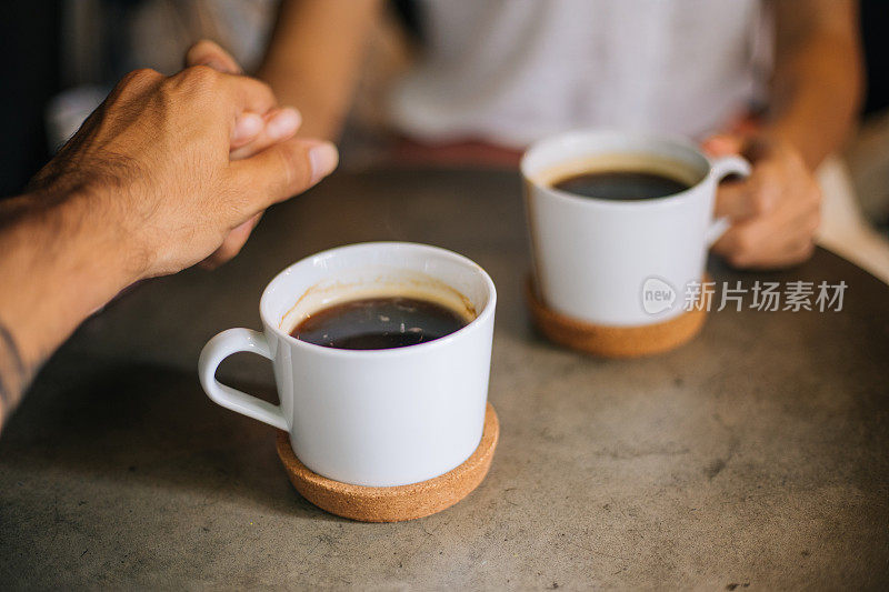 靠近女人和男人拿着咖啡杯在桌子上