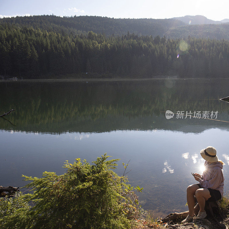 成熟的女人早晨在湖边放松