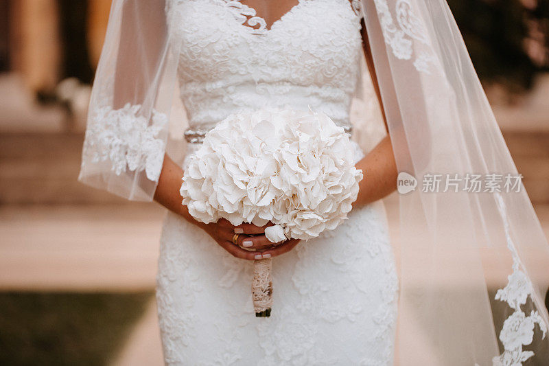 美丽的白色自然婚礼花束在新娘手中