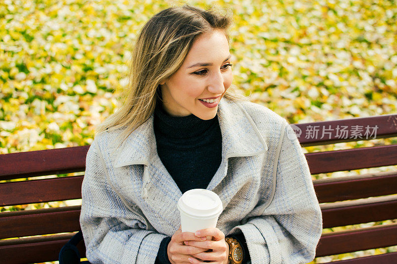 快乐的女人放松在公园喝一杯咖啡库存照片