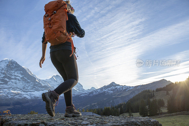 日出时分，女徒步旅行者在山脊上休息