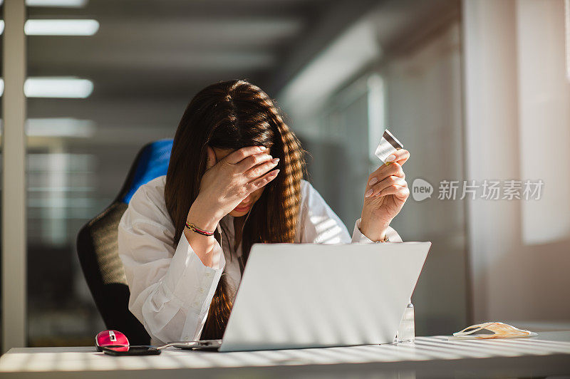 在办公室使用信用卡的女商人