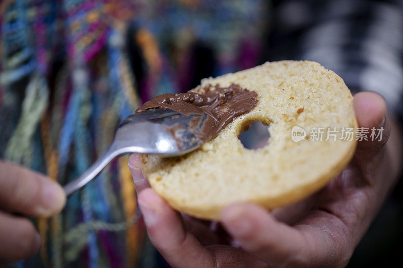 在自家做的百吉饼上撒巧克力