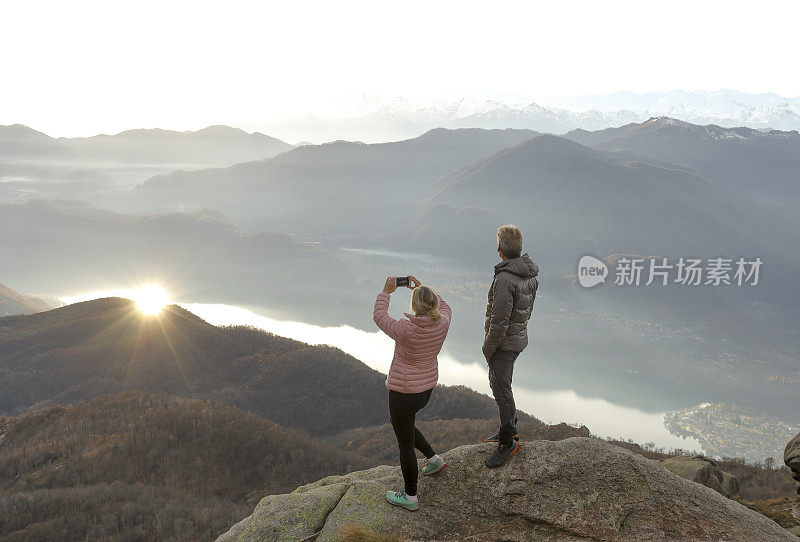 一对夫妇在湖上和山上拍摄日出