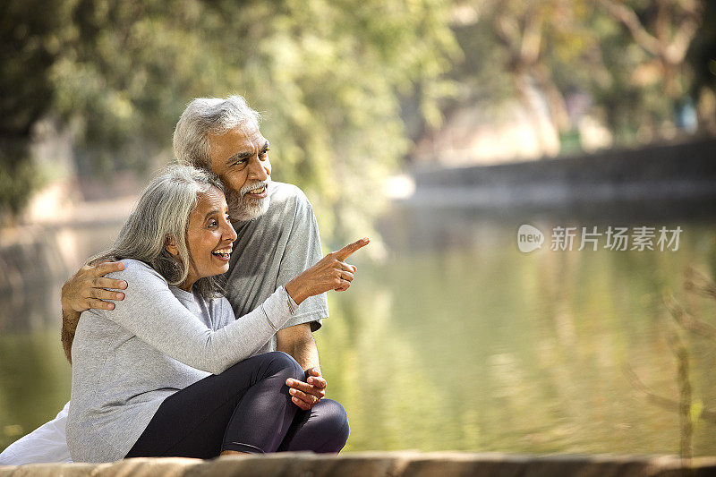 一对老年夫妇在湖边欣赏风景