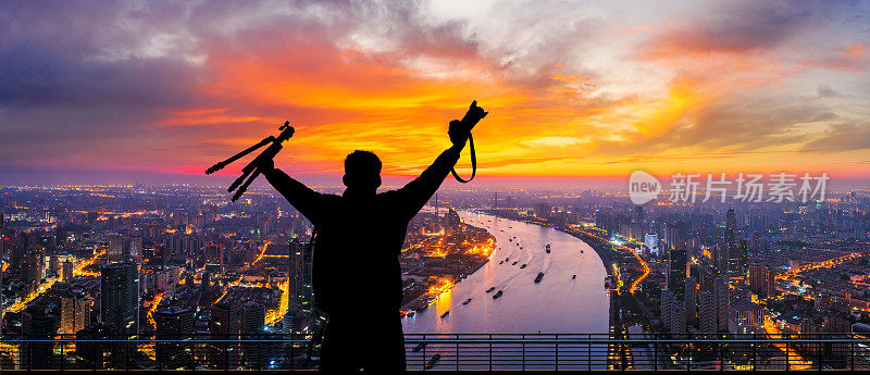 年轻的摄影师站在观景台上俯瞰上海城市的天际线。