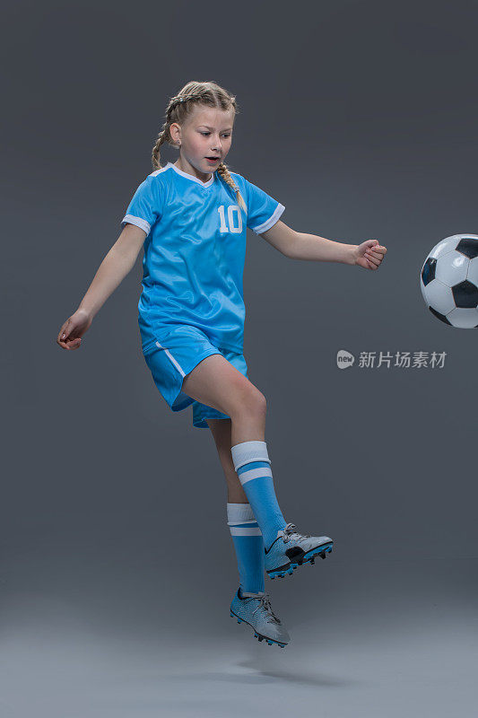 年轻的荷兰金发女足球女孩在摄影棚里拍摄