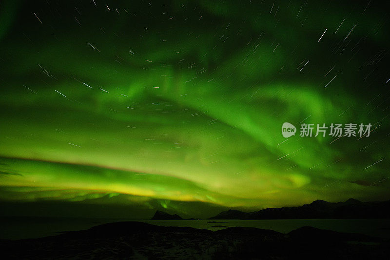 绿色的北极光在夜空和星星的轨迹