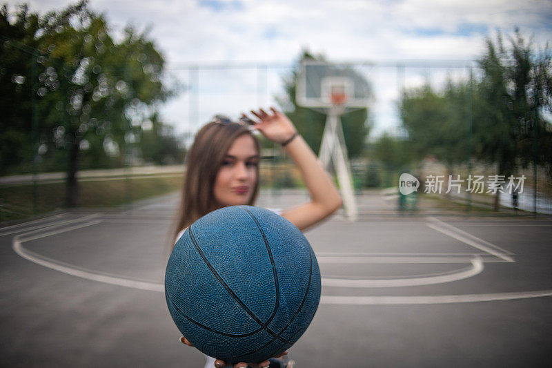 一个漂亮的年轻女子在篮球场上