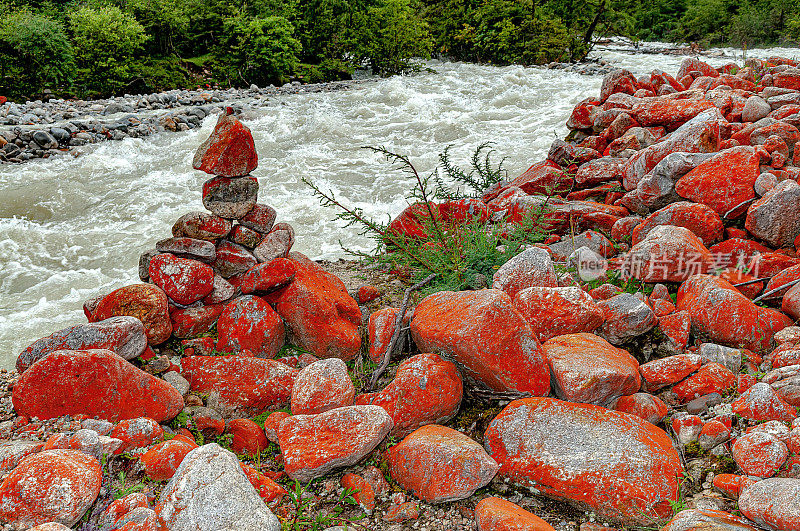 红色的石头在湍急的河流浙多，康定，中国，四川