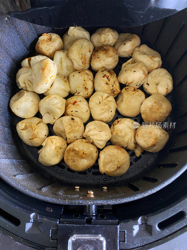 Momos(南亚饺子)图片，白面粉和水面团，填满鸡肉和混合蔬菜，在空气炸锅中烹饪，比煎锅更健康的选择，高架视野