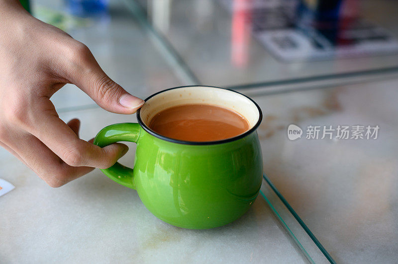 大理石桌上的一杯绿杯子的奶茶