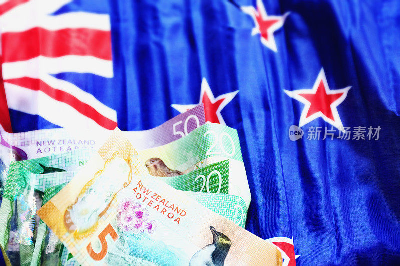 有新西兰国旗背景的新西兰货币(NZD)