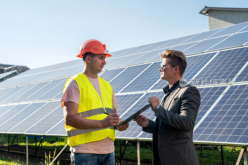 工人和客户在讨论每个太阳能电池板的项目成本