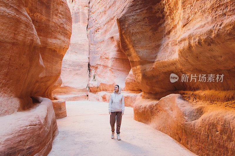 女旅行者在峡谷中行走，探索约旦佩特拉的古老世界