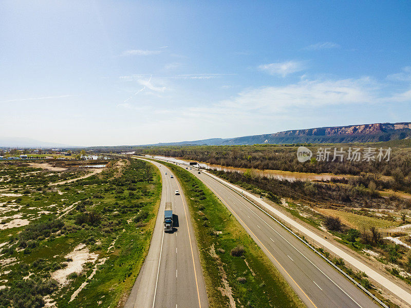 在美国西部70号州际公路和立交桥上行驶的车辆和卡车的半挂式无人机西行视图