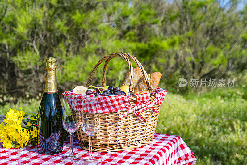 野地边的柳条野餐篮，里面装着食物和酒