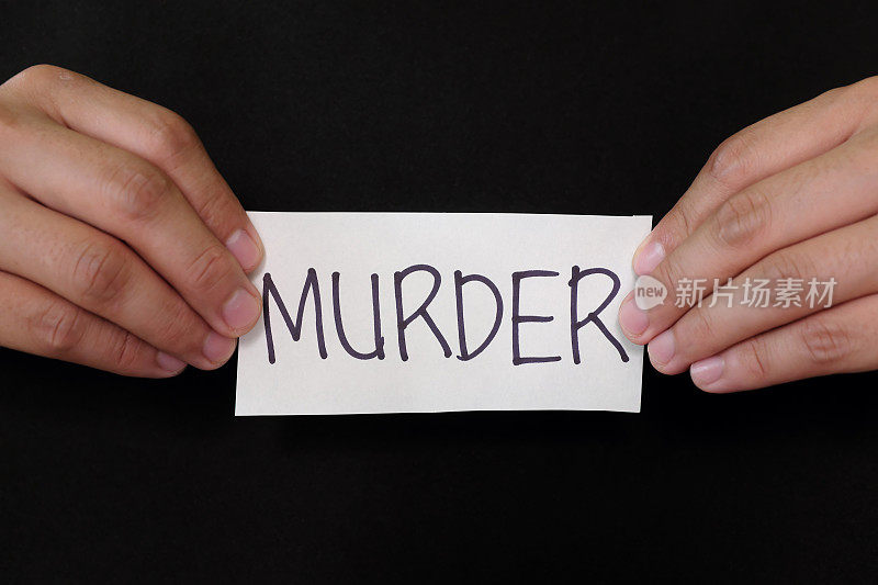 凶案大头照的概念。罪犯手里拿着黑底写着谋杀字样的纸牌。