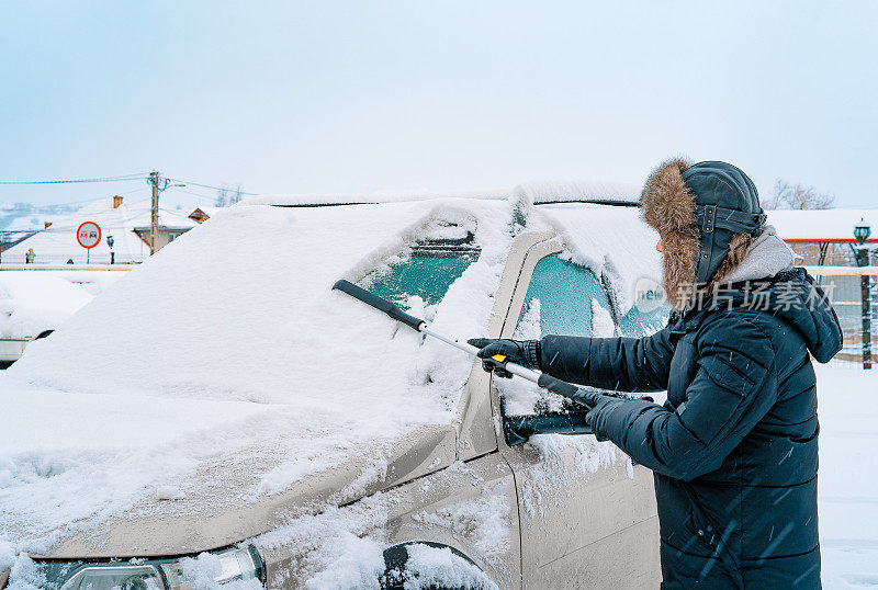 冬日里清扫车上积雪的人