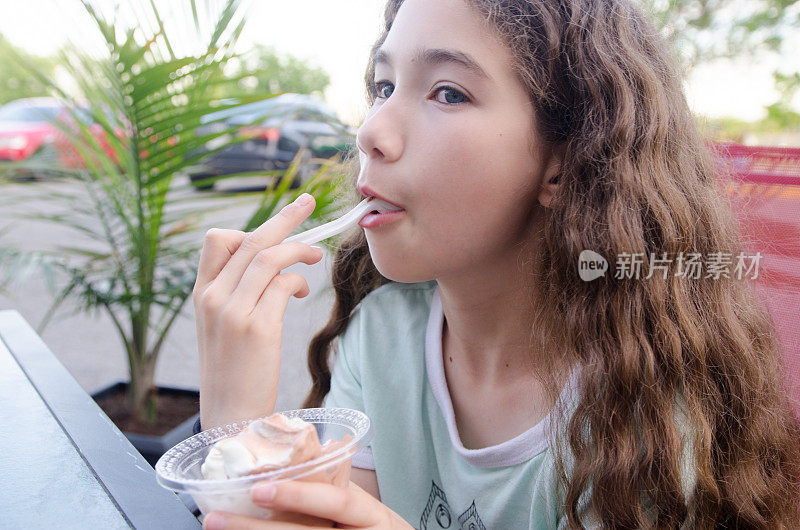十几岁的女孩吃着软冰淇淋