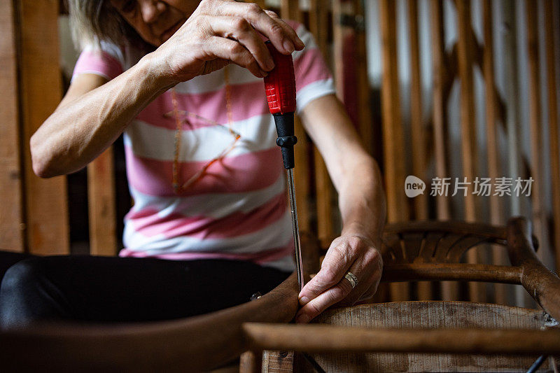 老婆婆退休了，在自己的车库式作坊里修木椅，这是她的爱好