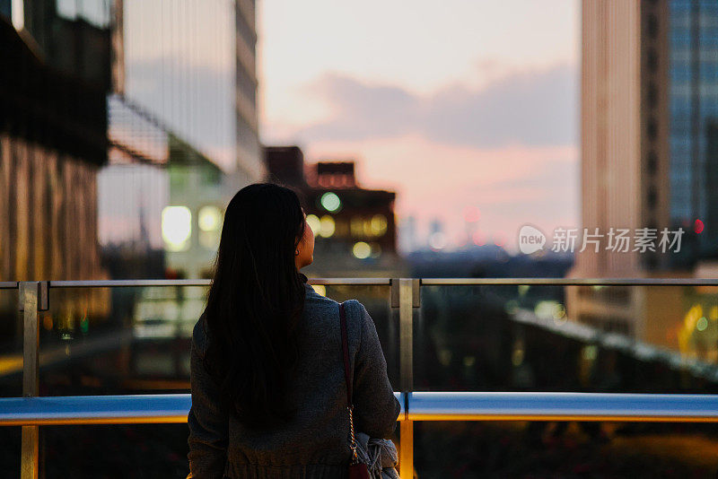 美丽的年轻女子享受夜晚的城市风景