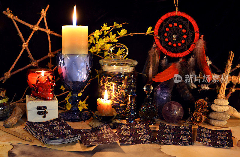 神秘的和神秘的静物与古老的魔法物品，塔罗牌和燃烧的蜡烛在女巫桌祭坛的神秘仪式和算命。万圣节和哥特式背景