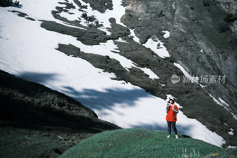 女徒步旅行者正在山里喝水