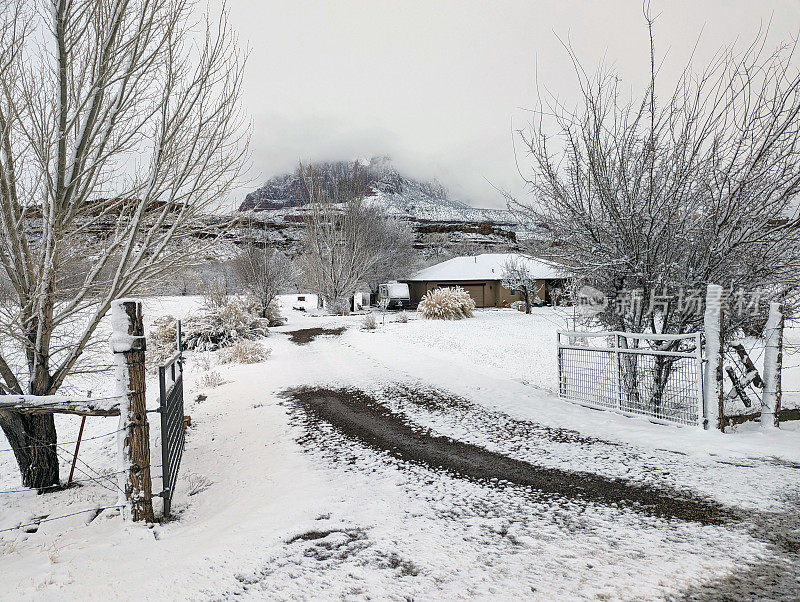 大雪过后，牧场的房子和沿着格拉夫顿路的车道，背景是锡安国家公园