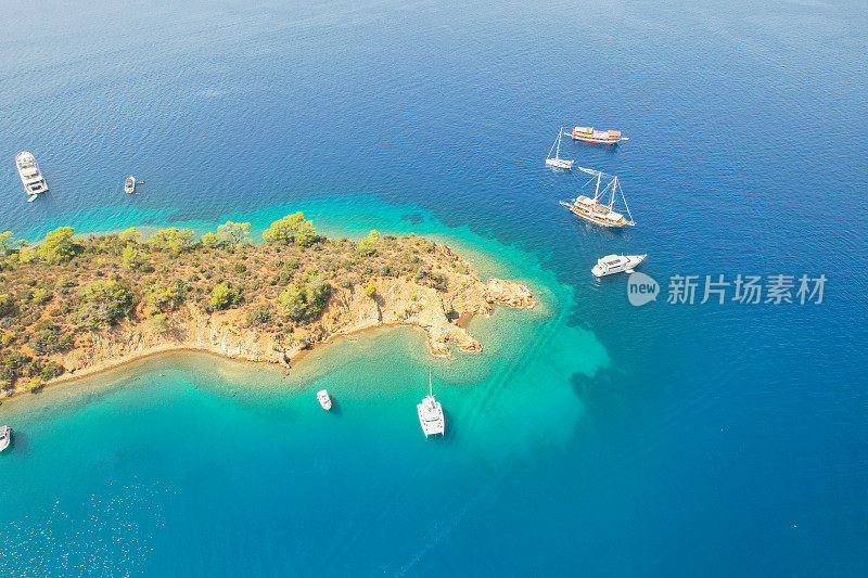 无人机拍摄的蓝绿色海面上环绕岛屿的船只